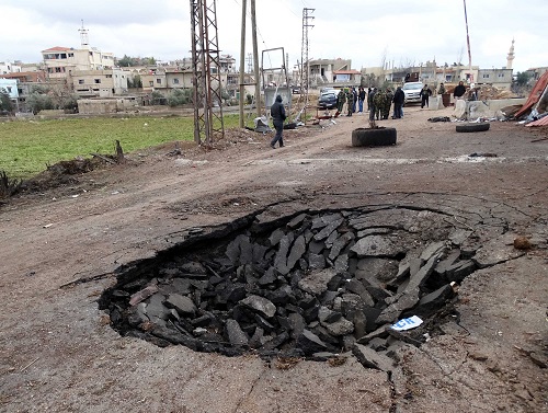 资料图：叙利亚首都大马士革西郊，汽车炸弹袭击后的地面露出大坑。新华社发