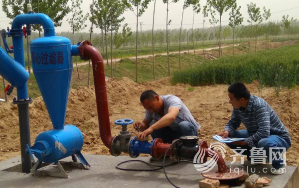 齐河县高效节水灌溉试点项目技术人员正在对过滤水泵进行调试