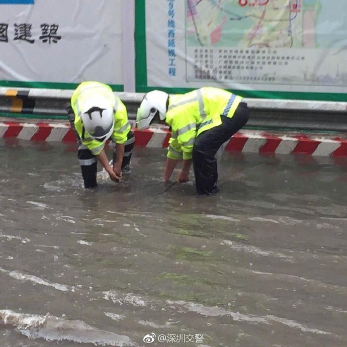 深圳交警为排水 撸起袖子拉井盖