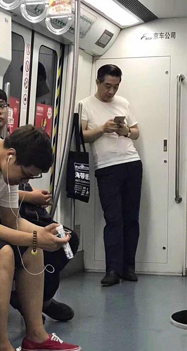 近日,一张"局座"张召忠身着白色t恤,斜倚在地铁车厢内玩手机的照片