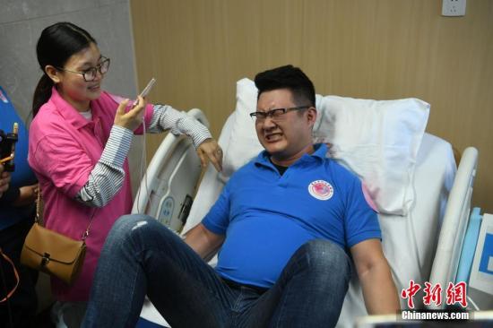 资料图：10余名已婚男士在重庆市妇幼保健院利用分娩阵痛模拟仪体验产妇分娩时的阵痛。陈超摄