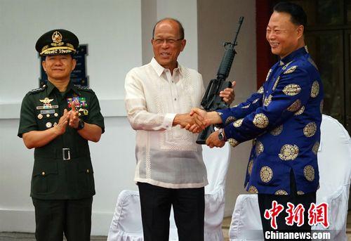 图为中国驻菲大使赵鉴华向(右)菲国防部长洛伦扎纳(中)和武装部队总参谋长阿诺移交反恐枪支。关向东摄