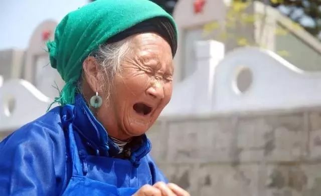 图为赵占英烈士母亲在儿子墓旁痛哭,20余年的阴阳两隔使老人泣不成声.