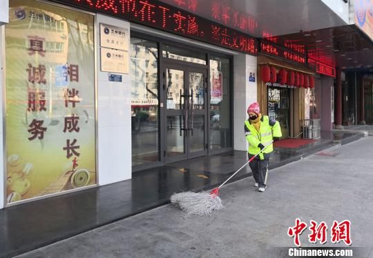 图为环卫工清扫门店外的垃圾。 刘薛梅摄 图为环卫工清扫门店外的垃圾。 刘薛梅摄