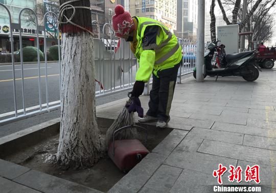 图为环卫工清扫树窝里的垃圾。 刘薛梅摄 图为环卫工清扫树窝里的垃圾。 刘薛梅摄