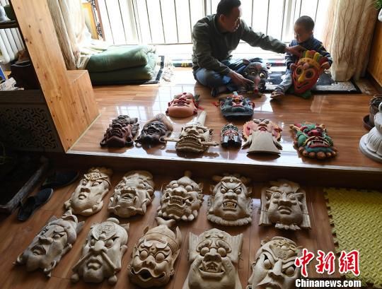 甘肃民间艺人马正德展示制作的傩面具。　杨艳敏摄