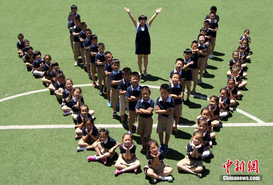 石家庄一年级小学生“结业照” 6月24日,在河北石家庄市保利启新小学的操场上,由学生组成的“one”字图形、“花朵”图形等各种创意无限的图案,吸引了众多师生的目光。据介绍,这场媲美大学经典毕业照的创意“结业照”,是由该校一年级升二年级的小学生及他们的老师和家长合力完成。一组组图案中,孩子们的童年将就此定格。