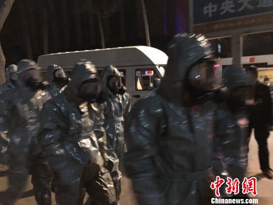 十几名身着防护服的人员头戴面具进入事发地。　胡健摄