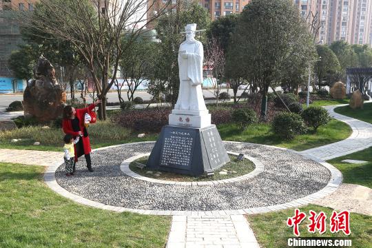 一位母亲为孩子讲解包拯清廉为民的故事。　李涛 摄