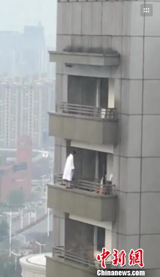 南京一年轻女子因感情问题，裹浴衣29楼上欲轻生。　申冉摄