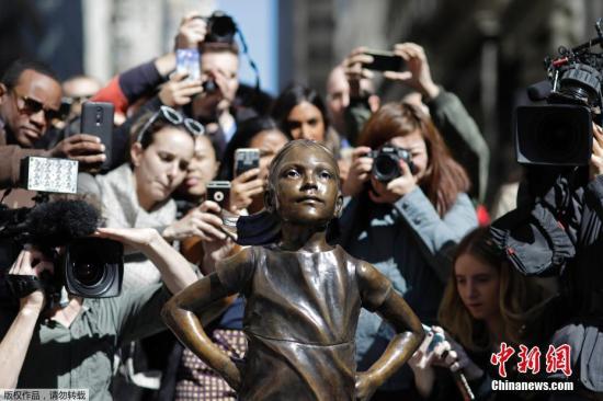 当地时间3月15日，美国纽约华尔街上，一尊名为“无所畏惧的女孩”铜像成为人们争相合影的新景点。该铜像在3月8日建起，女孩双手叉腰面朝著名的华尔街铜牛。据悉，该作品是一家企业为了唤起女性领导力量，加入到公司的董事层。该雕像由艺术家克里斯汀&middot;比斯瓦尔创作，将在纽约曼哈顿展出至少一周的时间。