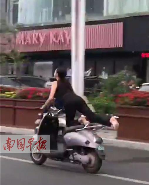 女子在骑电驴过程中，不断将腿抬高。视频截图