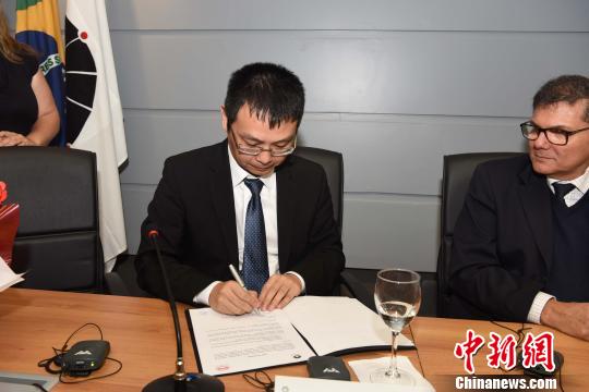 比亚迪巴西有限公司总经理李铁(左)签字。　莫成雄 摄