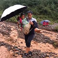 暴雨中，云南一小学老师往返湍急河水抱67名孩子过河