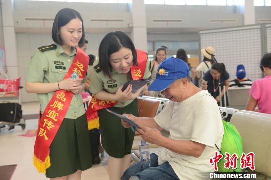 边检官兵向旅客发放宣传册。　范海超　摄