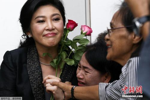 资料图：当地时间2017年8月1日，泰国前总理英拉抵达最高法院出席大米收购案结案辩护陈词，民众送上玫瑰花