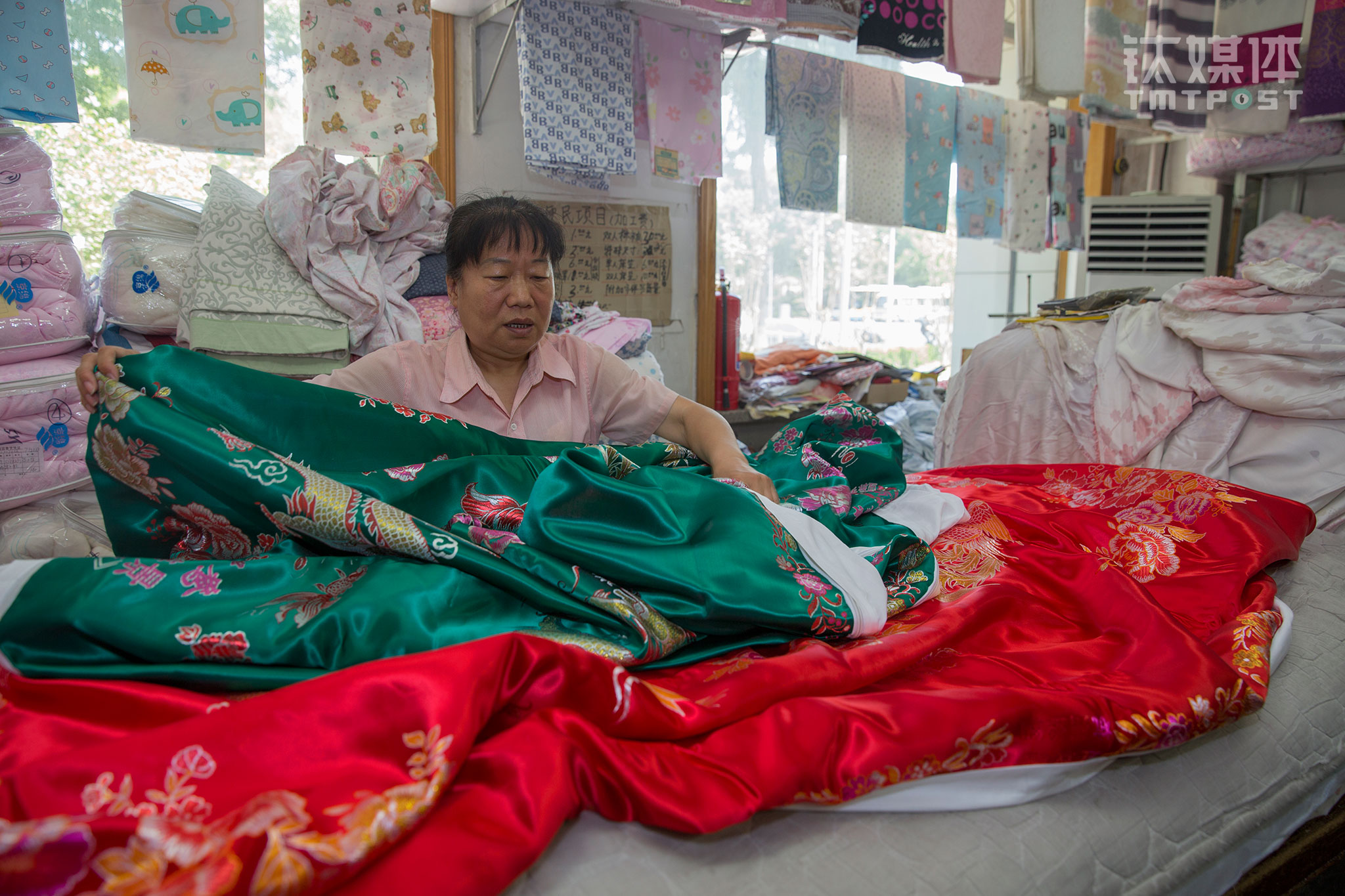 On June 20th, 2017, Liu Huirong from Dafang’s fabric section was sorting out some blanket sheets for the customer. The sheets were for a wedding. “The red one is for the groom and the green one is for the bride. They have patterns of the dragon, phoenix, and peony on them. Usually, people buy a pair. You know, the old generation likes it.”