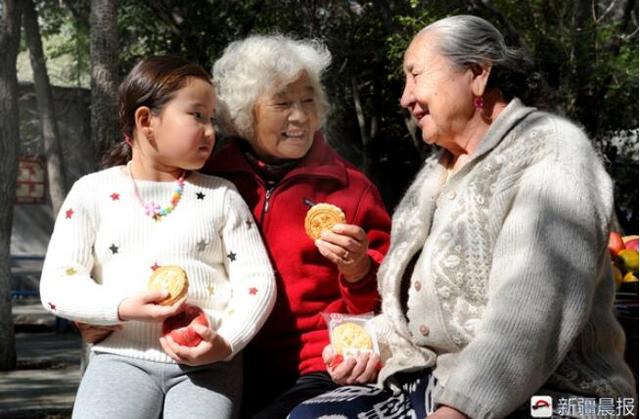 两位老人在一起品月饼、聊中秋的话题。