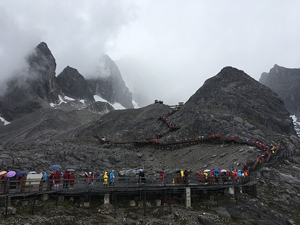 玉龙雪山环卫工:悬崖上拴绳捡垃圾 每天运百余斤粪便