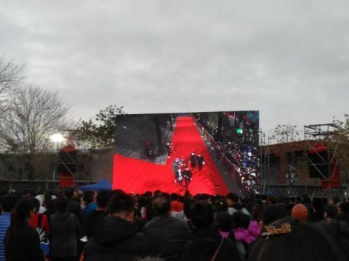 附近居民在电影宫内的空地上观开幕红毯直播