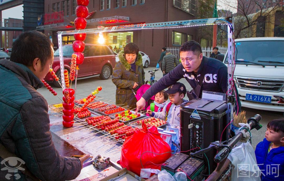 为了招揽顾客,他从中拿出一部分钱,买了三轮车和制作冰糖葫芦的原材料