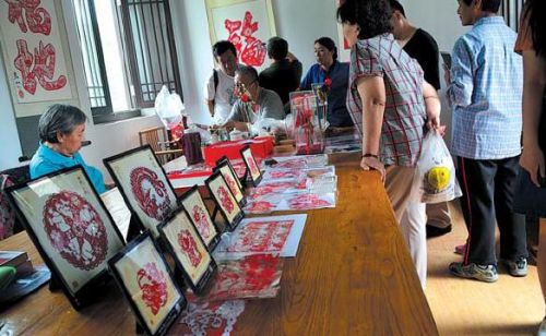 非遗艺人被众多市民围观。本报记者于悦摄