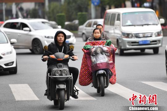 资料图：民众穿上厚衣物骑行。　张浪 摄