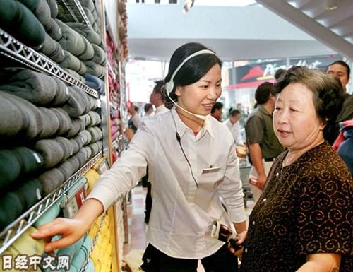 中国侨网资料图片:上海优衣库的店员在为顾客讲解。(图片来源:《日本经济新闻》网站)