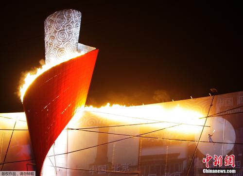 资料图：2008年8月8日晚上8时整，北京奥运会开幕式在“鸟巢”正式举行。“体操王子”李宁以钢线吊到高空，“空中漫步”绕场一周后，点燃“祥云”造型的主火炬。