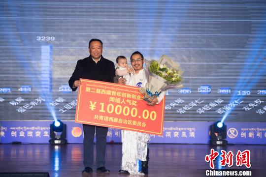 图为强巴(右一)的本土文化创意项目获得网络人气奖。 何蓬磊 摄