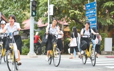 2017年8月15日，在泰国曼谷的泰国国立法政大学，学生们使用ofo小黄车出行。 新华社记者 李芒茫摄