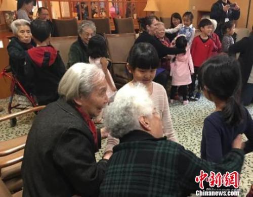 资料图：北京一家养老机构内，老人们与幼儿园小朋友一起做游戏。　杜燕摄