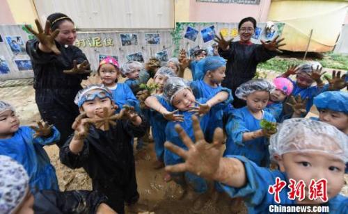 资料图：江西省新余市蓓蕾幼儿园大一班的孩子们在老师带领下抓泥鳅、打泥仗。　赵春亮摄