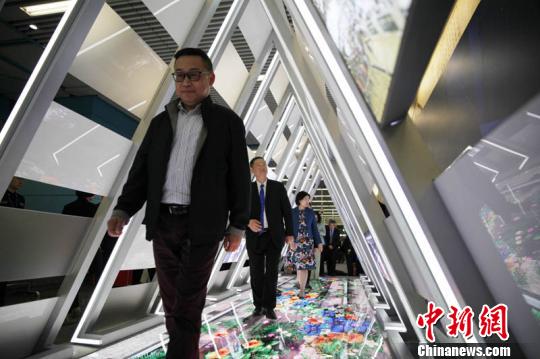 “京港中学生地铁列车模型创意科技大赛”在北京启动。图为嘉宾们走进启动仪式现场搭建的一个三角形“隧道”，其内设3D全息投影，地面上的轨道会随着乘客行进的步伐幻化出绿植、鲜花，表达美好寓意。　张宇亮 摄