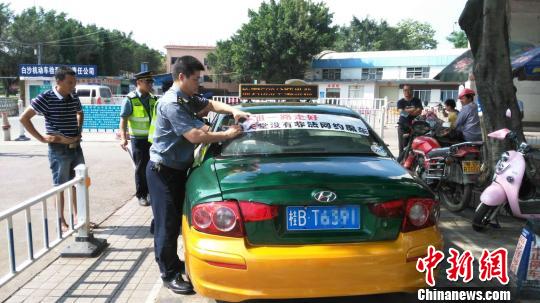 5月19日，柳州市交通综合行政执法支队联合各出租车公司上街执勤，对未经批准擅自粘贴标语的出租车，当即通知自行清理干净。　钟欣摄