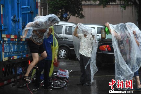 重庆主城突降暴雨 街头民众自制雨衣避雨