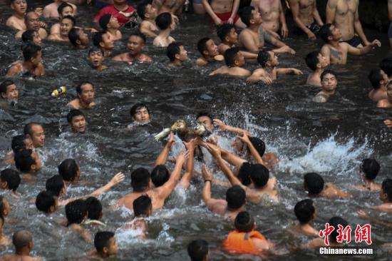 6月18日，正值端午佳节，湖南凤凰古城沱江河上一年一度的抢鸭子习俗吸引了数万游人围观。杨华峰 摄
