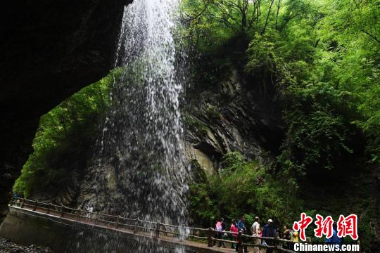 游客在瀑布下拍照留念。 杨艳敏 摄 游客在瀑布下拍照留念。 杨艳敏 摄