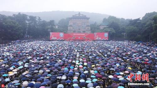 资料图：2018年6月22日，武汉大学举行2018年毕业典礼暨学位授予仪式，万余名师生坚持在雨中完成毕业典礼，气氛感人。 图片来源：东方IC