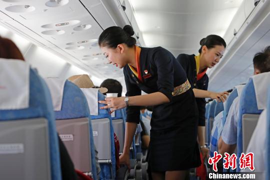 成都航空乘务员正在ARJ21支线客机上为旅客服务。　殷立勤 摄