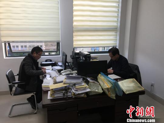 图为纪检组在检查账本。　张莉 摄