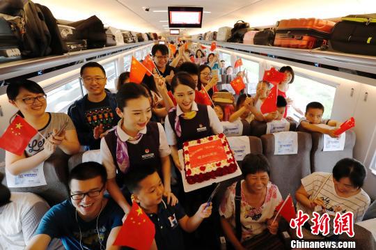 长编组“复兴号”动车组,列车员与旅客庆祝这一时刻。 殷立勤 摄 长编组“复兴号”动车组,列车员与旅客庆祝这一时刻。 殷立勤 摄