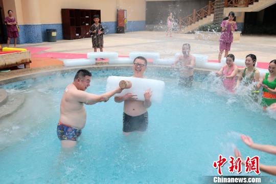 图为游客在冰泉里抱冰块戏水降温。　韩章云　摄