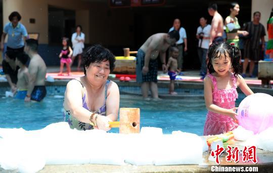 图为游客在冰泉里砸冰块戏水降温。　韩章云　摄