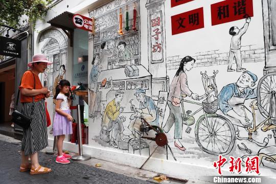孩子在石库门画前体验老物件。　殷立勤 摄