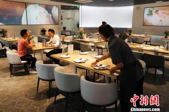 工作人员正在布置共享餐厅座位区。　殷立勤 摄