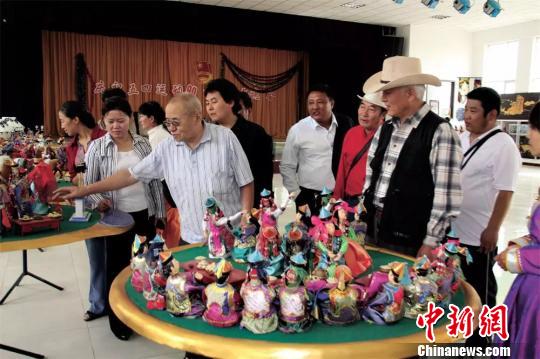 图为曹纳木(左前一)介绍鄂尔多斯婚礼布偶。 受访者供图 摄 图为曹纳木(左前一)介绍鄂尔多斯婚礼布偶。 受访者供图 摄