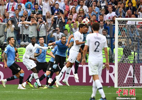 随着比赛的进程，法国队慢慢将进攻渗透到乌拉圭队的半场，但却未能获得射门机会。第38分钟，本坦库尔在本方禁区边缘对托利索铲球犯规，裁判向其出示黄牌。随后格里兹曼罚出任意球，法国队后卫瓦拉内跟上头球后蹭球门远点，穆斯莱拉扑救不及目送皮球入网，法国队1:0领先。 中新社记者 毛建军 摄