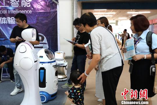 市民们与机器人“小胖”进行互动。 胡耀荣 摄 市民们与机器人“小胖”进行互动。 胡耀荣 摄