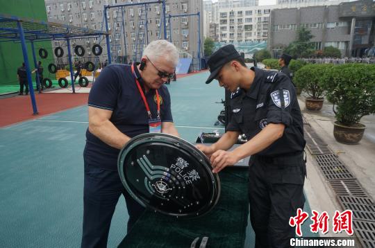图为一名驻华执法联络官向中国警察了解警用装备的使用方法。 韩章云 摄 图为一名驻华执法联络官向中国警察了解警用装备的使用方法。 韩章云 摄